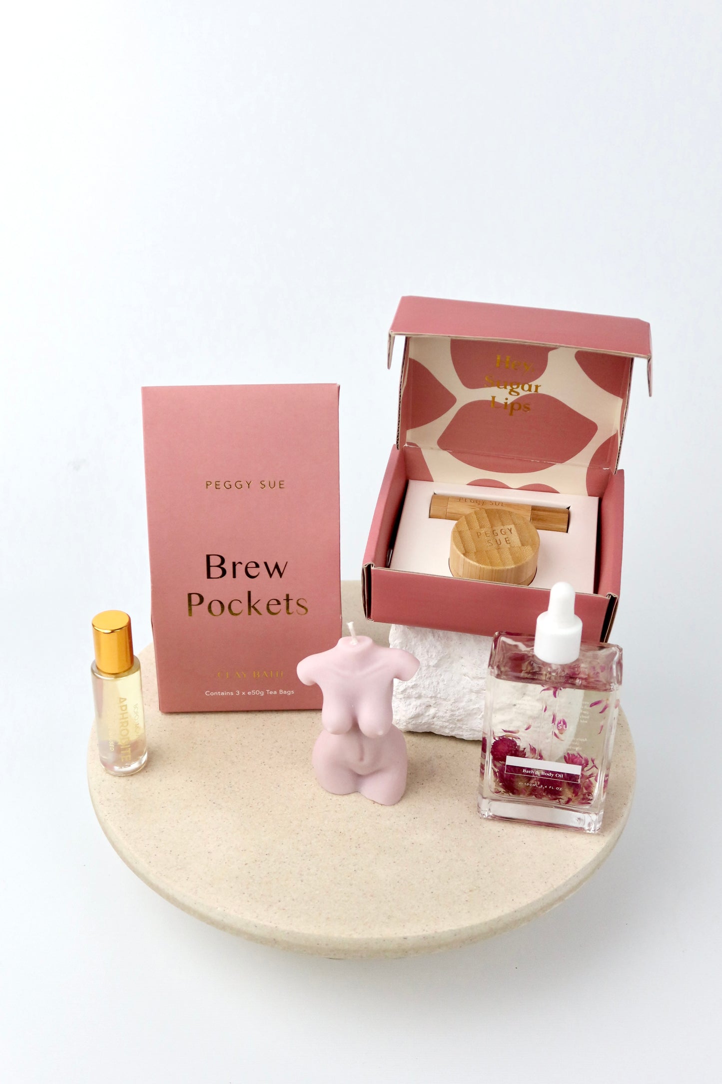 The 'Glow' Gift box. This bath and body hamper includes Bath brew pockets and a silk ip care kit by Peggy Sue. A crystal perfume roller and Spring of seed body oil by Bopo Women and a handmade soy wax lady figure candle.