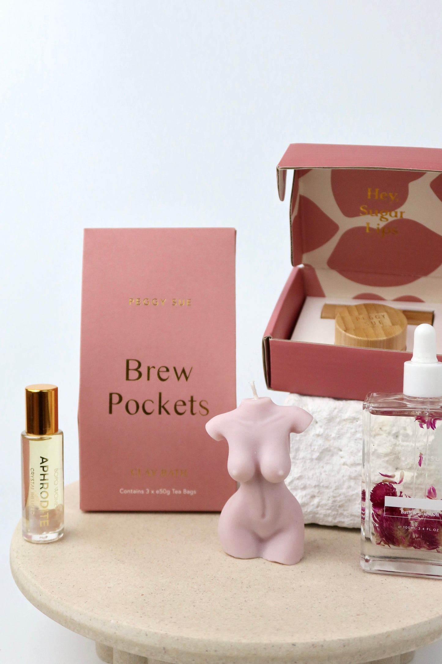 The 'Glow' Gift box. This bath and body hamper includes Bath brew pockets and a silk ip care kit by Peggy Sue. A crystal perfume roller and Spring of seed body oil by Bopo Women and a handmade soy wax lady figure candle.