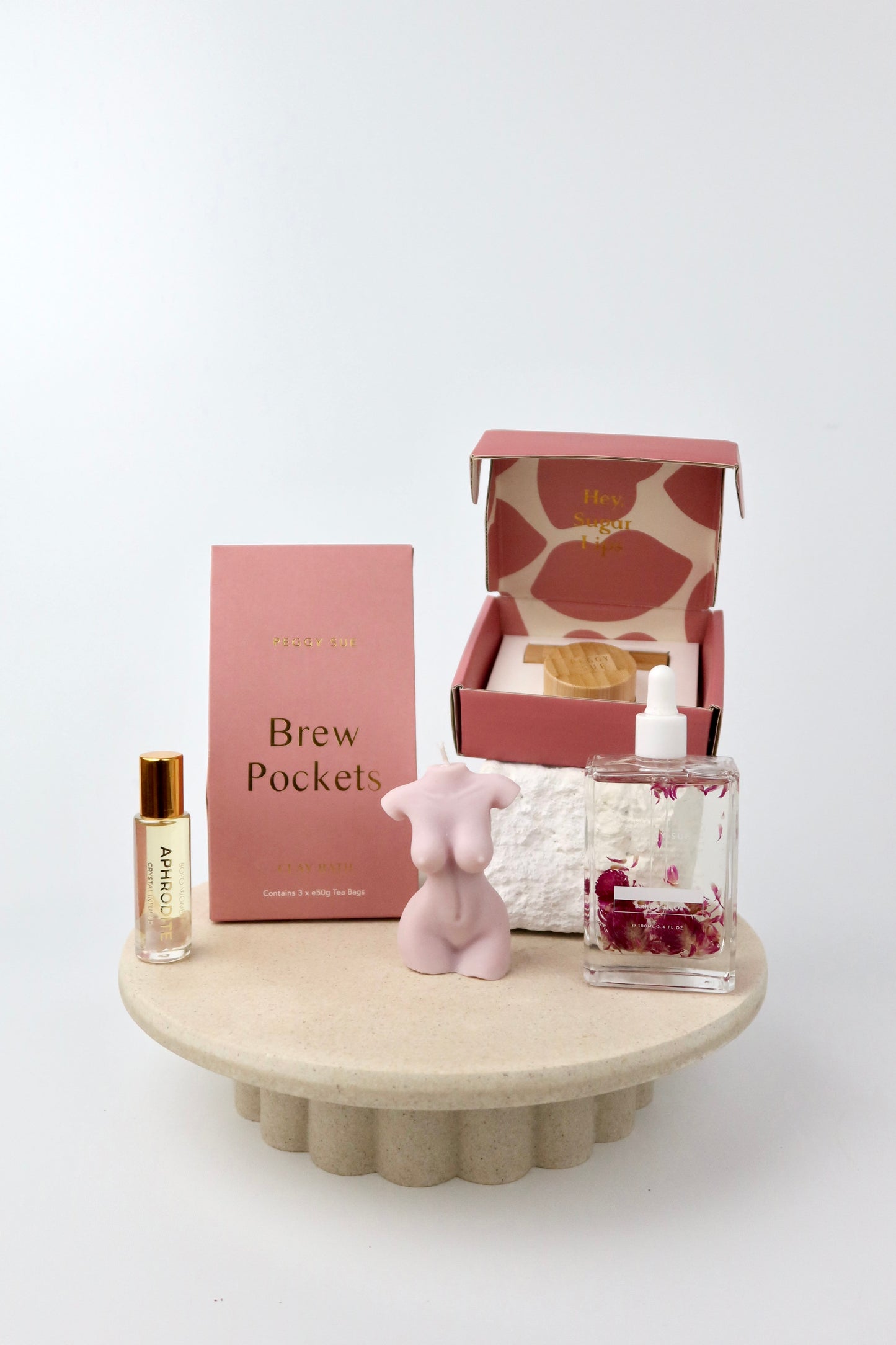 The 'Glow' Gift box. This bath and body hamper includes Bath brew pockets and a silk ip care kit by Peggy Sue. A crystal perfume roller and Spring of seed body oil by Bopo Women and a handmade soy wax lady figure candle. 