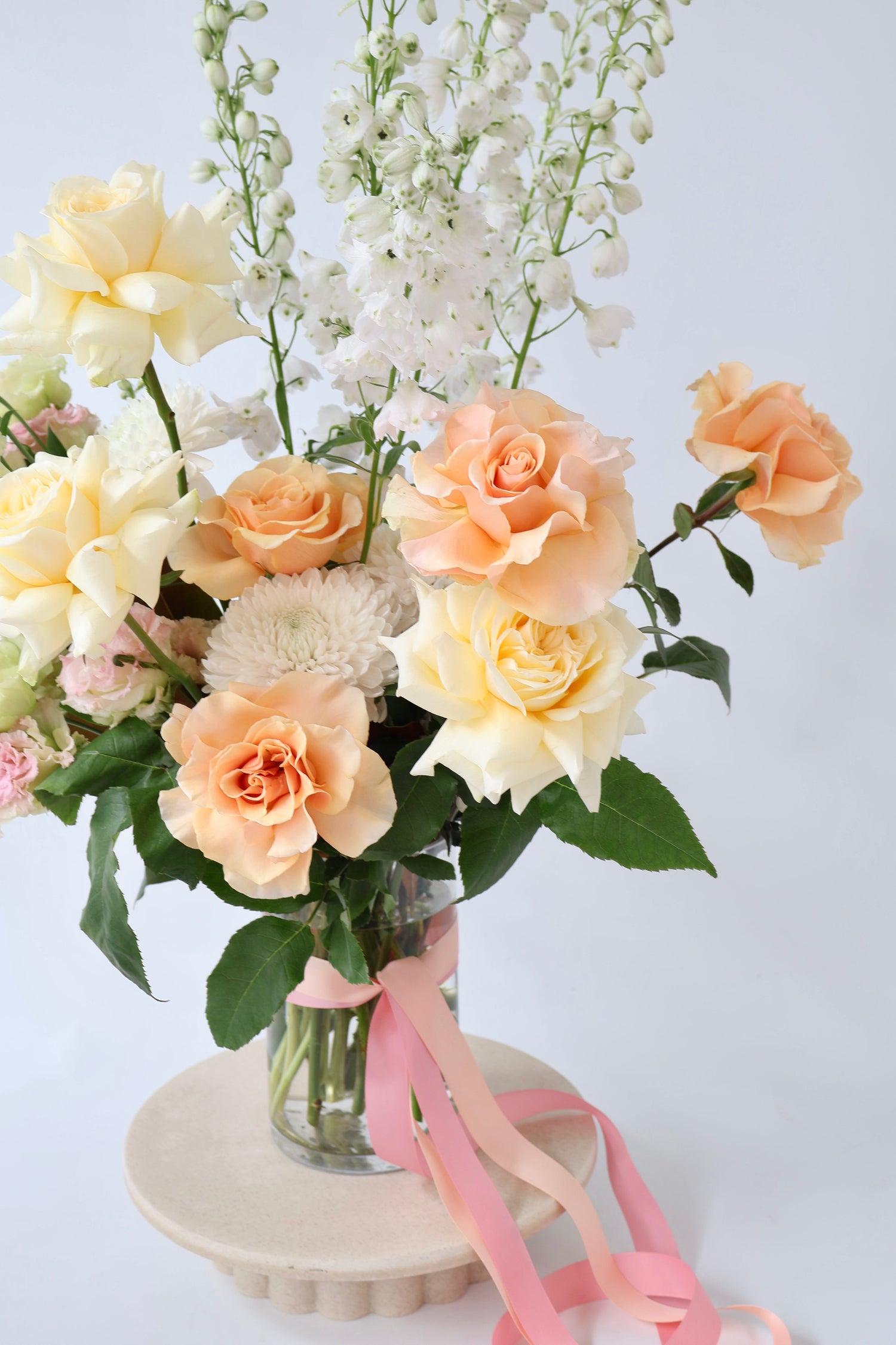 A deluxe fresh flower arrangement in glass vase with Dr Joyful rose and vanilla bath soak.