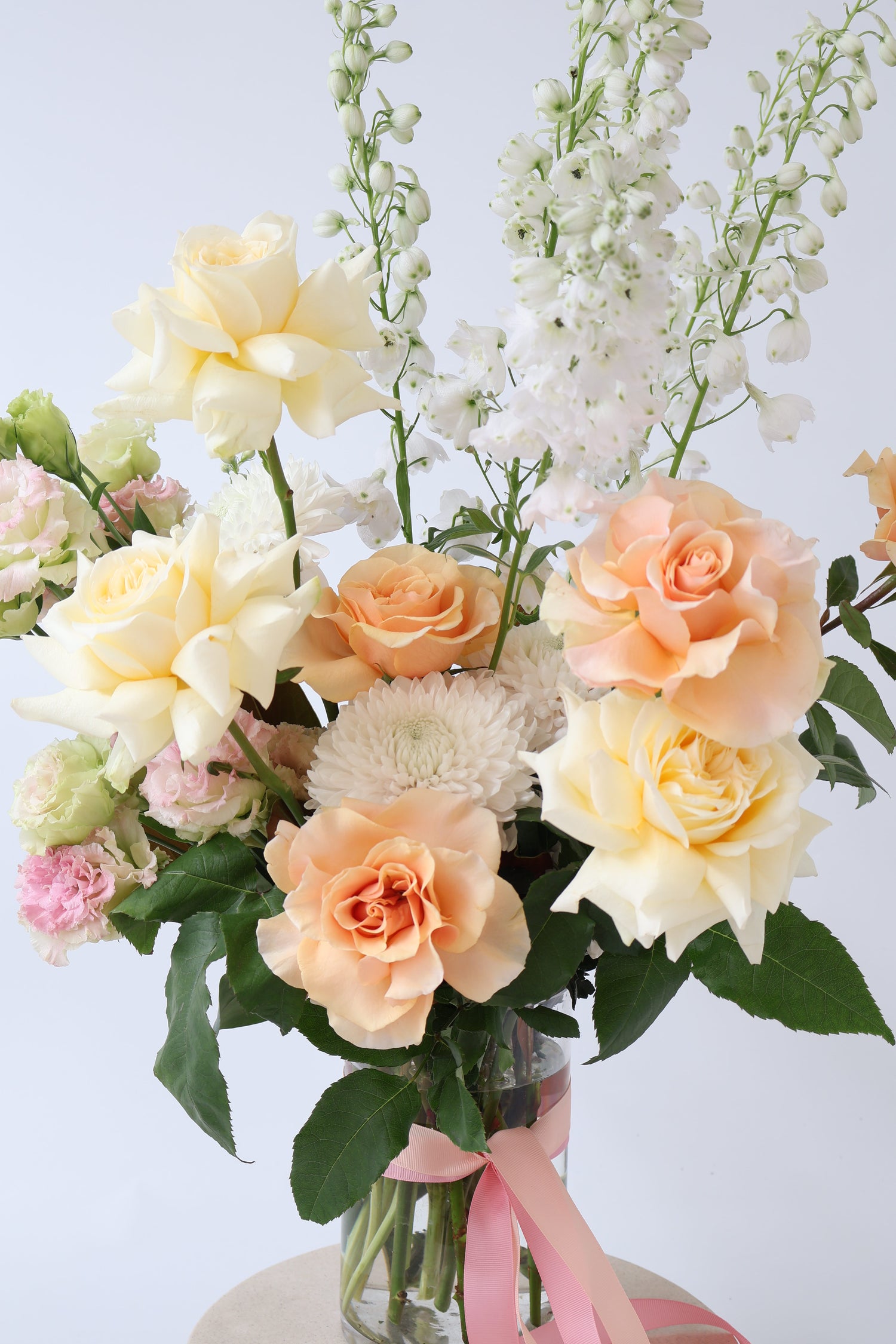 A deluxe fresh flower arrangement in glass vase with Dr Joyful rose and vanilla bath soak.