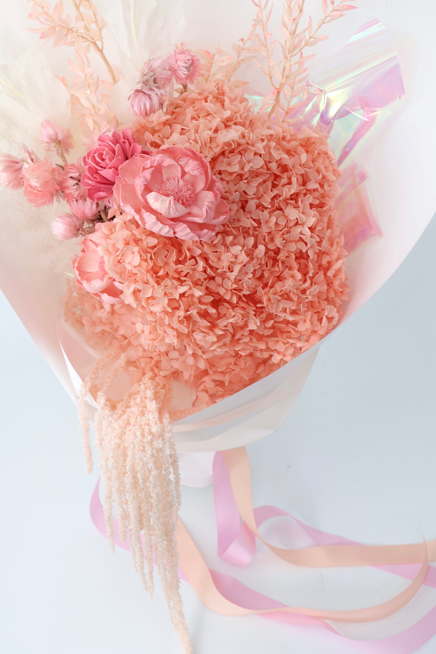 A dried flower bouquet in shades of pink and cream whites.