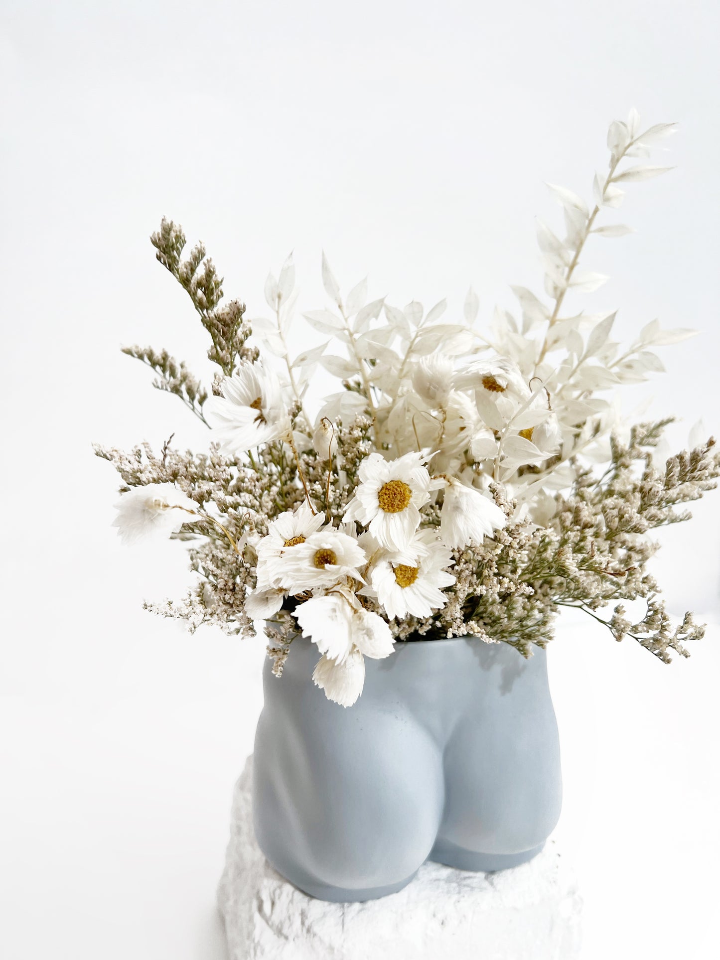 An everlasting flower arrangement in white dainty dried and preserved florals in our soft blue tush vase from Jones and Co, handmade fine porcelain