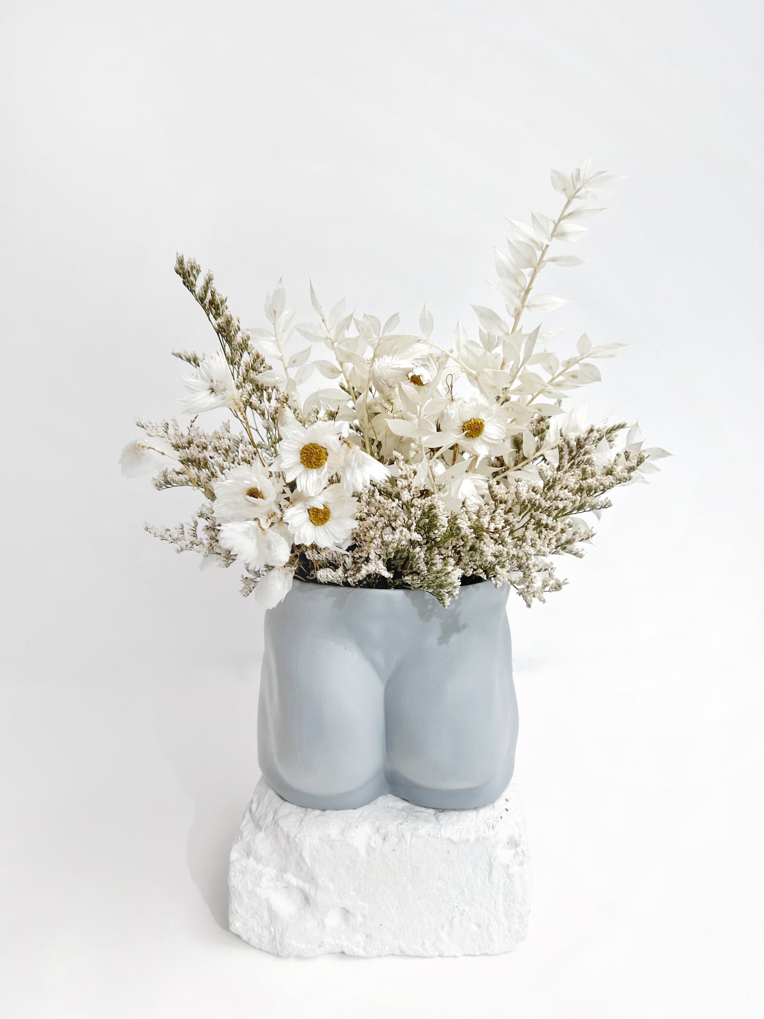 An everlasting flower arrangement in white dainty dried and preserved florals in our soft blue tush vase from Jones and Co, handmade fine porcelain.