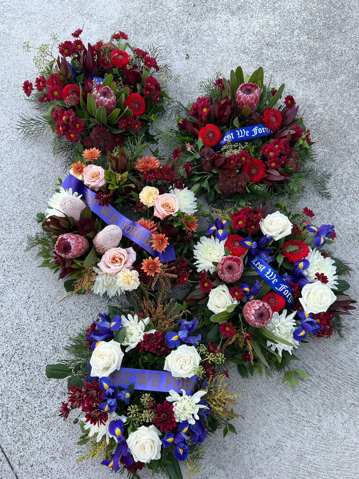 Wreath flower arrangements for symapthy and tribute occasions with Lest We Forget ribbon. 