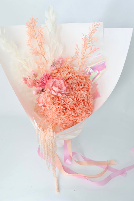 A dried flower bouquet in shades of pink and cream whites.