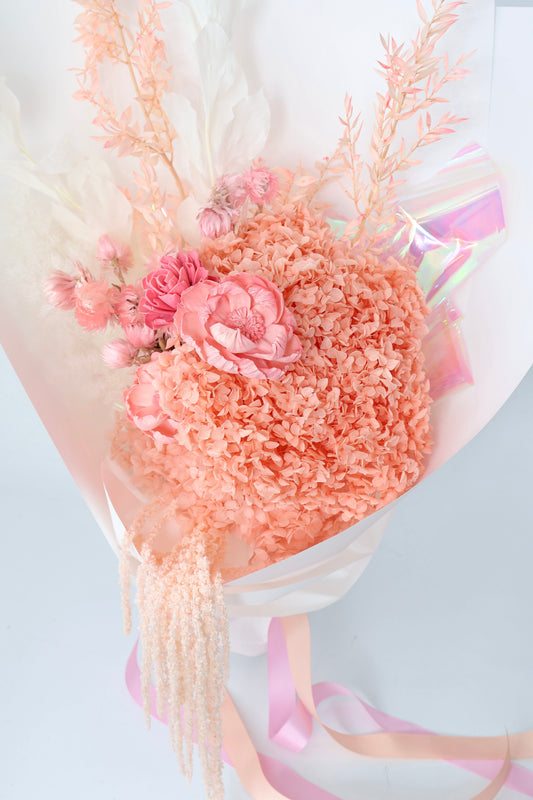 A dried flower bouquet in shades of pink and cream whites.